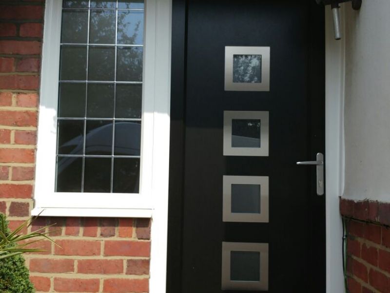 Upvc door and side flag window with white outer frame and anthracite grey door sash and infill panel: Swipe To View More Images